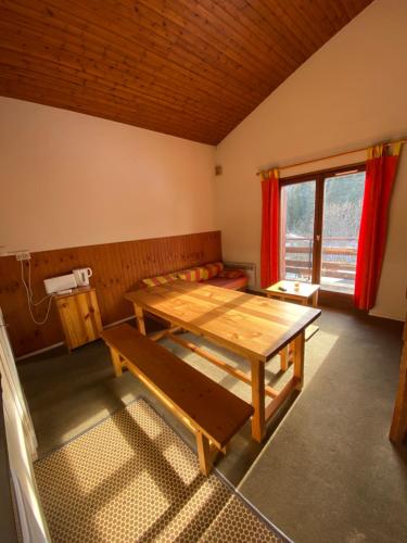 Cette chambre dispose d'une table en bois et d'une fenêtre. dans l'établissement Amethyste, à Saint-Gervais-les-Bains