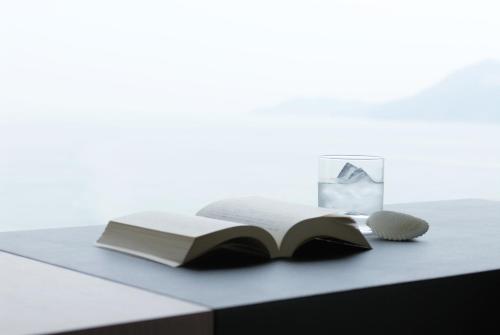 an open book on a table with a glass at Toba International Hotel in Toba