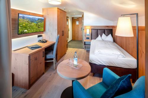 a hotel room with a bed and a desk at Hotel Helmer in Schwangau