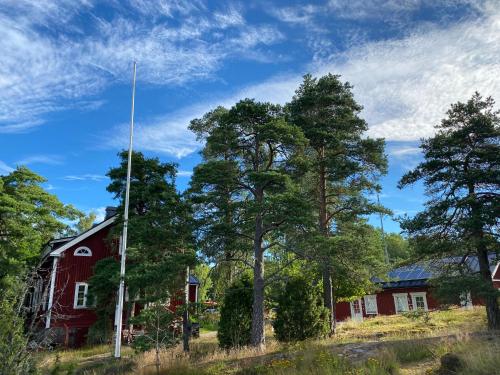 a red barn and trees in a field at Villa Sofia Barösund in Inkoo