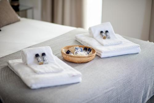 two white towels and a bowl on a bed at Alcântara Factory I in Lisbon
