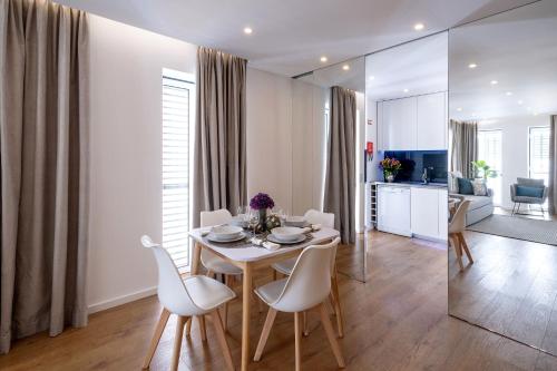 a living room with a table and chairs and a kitchen at Alcântara Factory I in Lisbon