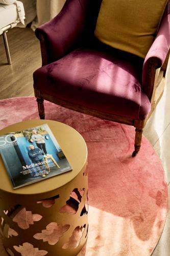 a table with a book on it next to a chair at DysArt Boutique Hotel - Solar Power in Cape Town