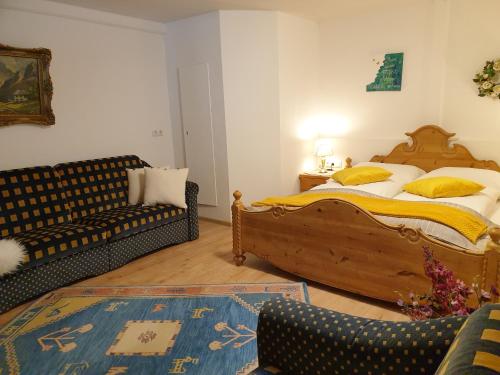 a bedroom with a bed and a couch at Hofstätter Ferienwohnung in Fliess