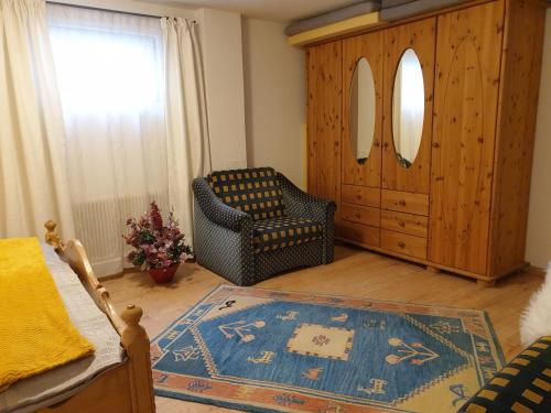 a living room with a chair and a dresser at Hofstätter Ferienwohnung in Fliess