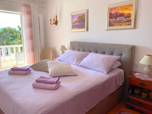 a bedroom with a bed with pink pillows on it at Guest House Meri in Bol