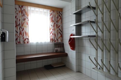a tiled bathroom with a bench and a window at Apart La Stella in Kappl