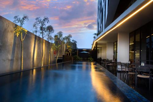 ein Schwimmbad in der Mitte eines Gebäudes in der Unterkunft Neo Hotel Tendean Jakarta by ASTON in Jakarta