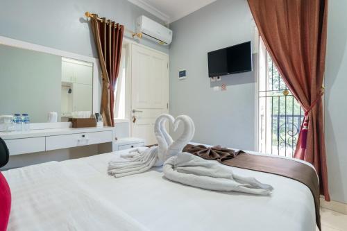a bed with a towel in the shape of a heart at Fast Hous Syariah Bogor Mitra RedDoorz in Bogor
