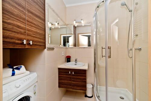 a bathroom with a sink and a shower at BlueApart Apartamenty Na Klifie in Władysławowo