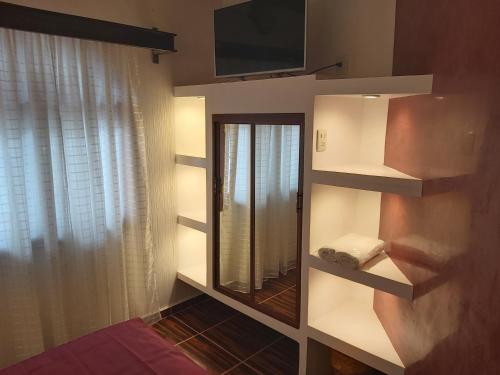 a bathroom with a mirror and a tv on a wall at Hotel Boutique TEKALI INN in Cuetzalán del Progreso