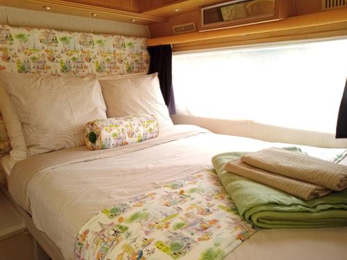 Bett in einem Zimmer mit Fenster in der Unterkunft Luna caravane Vintage in Charron