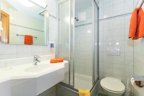 a bathroom with a sink and a toilet and a shower at Pension Seighof in Saalbach Hinterglemm