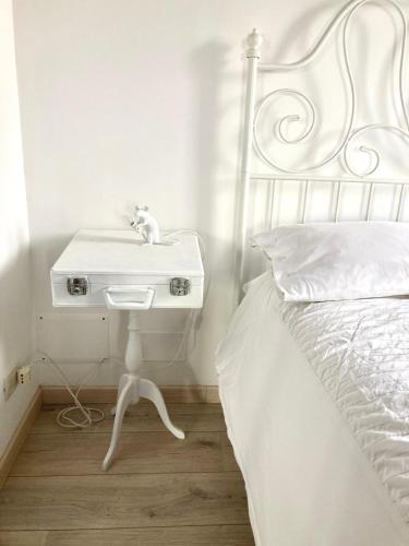 a white bed with a white sink next to a bed at Castel Apartment in Castellamonte
