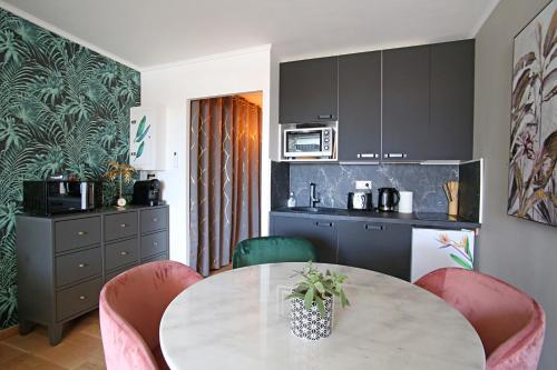 - une cuisine avec une table, des chaises et un comptoir dans l'établissement T2 COSY CÔTÉ PLAGES QUARTIER DES QUILLES, à Sète