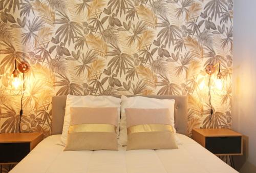 - un lit avec deux oreillers devant un mur dans l'établissement T2 COSY CÔTÉ PLAGES QUARTIER DES QUILLES, à Sète