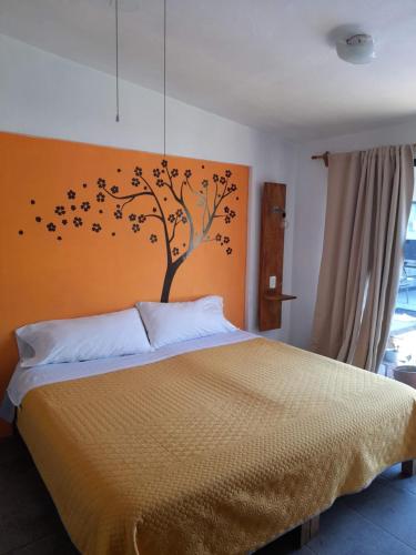 una camera da letto con un letto con un albero con sopra degli uccelli di Posada Casa Topiltzin a Tepoztlán