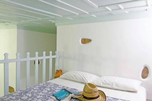una camera da letto con un letto con un cappello sopra di Nikola's Place a Astypalaia Town