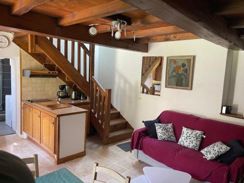 - un salon avec un canapé rouge et un escalier dans l'établissement An ti Bihan, Gite Breton à la campagne, à Tonquédec