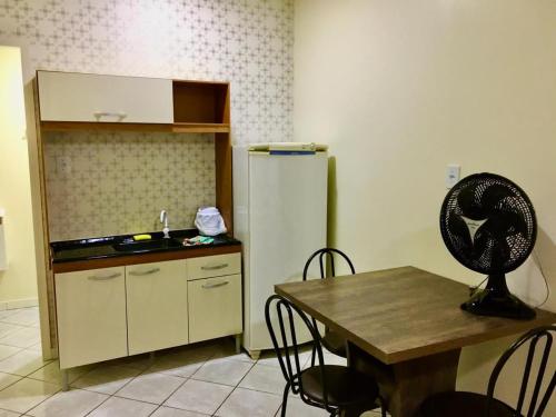a kitchen with a table and a refrigerator at Flat no centro in Chapecó