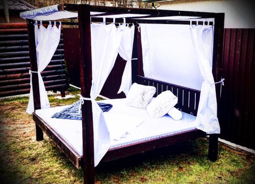 a black bed with white sheets and pillows on it at TRENDY HOUSE 193 in Mátranovák