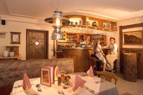 a group of people sitting at a bar in a restaurant at Pension Seighof in Saalbach Hinterglemm