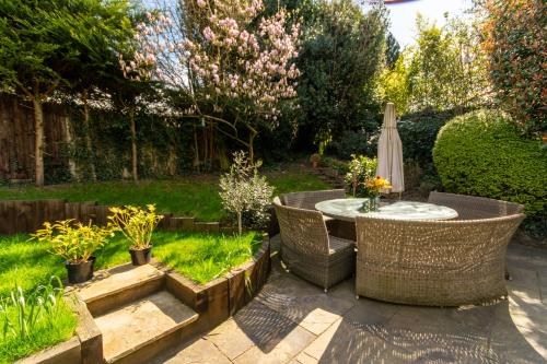 a large garden with a large tub and a stone wall at The Mills Guesthouse Hatfield in Hatfield