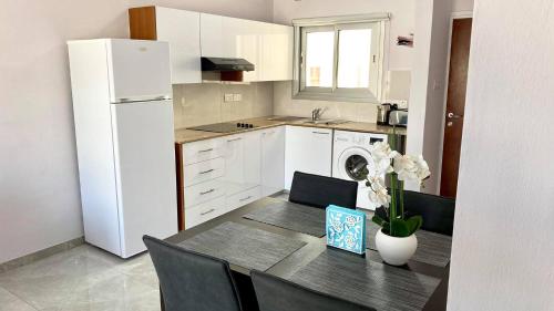 a kitchen with a table and a white refrigerator at Napa Court 2 in Ayia Napa