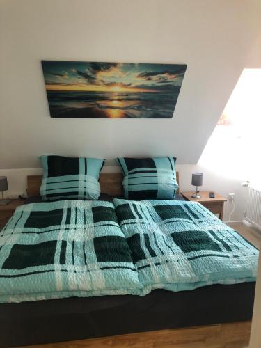 a bedroom with a bed with a blue and white comforter at Marktblick in Norden