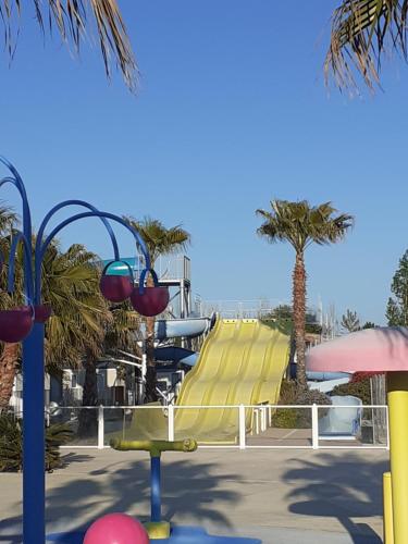 un toboggan dans un parc aquatique avec des palmiers dans l'établissement la carabasse, à Vias