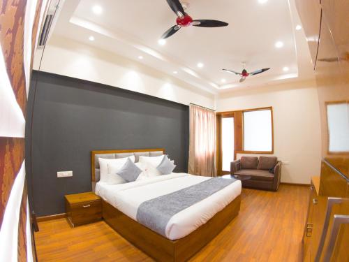 a bedroom with a large bed and a chair at Hotel Vishal Imperial in Rohtak