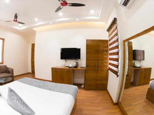 a bedroom with a bed and a desk and a tv at Hotel Vishal Imperial in Rohtak