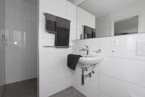 a white bathroom with a sink and a shower at Gasthaus Krone Lenggenwil in Zuckenriet