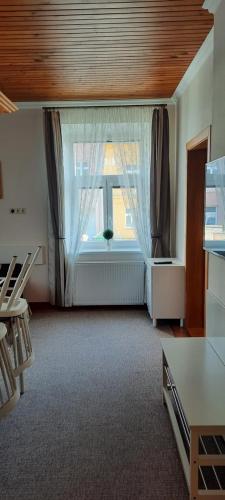 a living room with a large window with curtains at Villa Shafaly in Mariánské Lázně