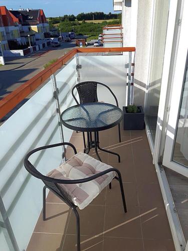 - Balcón con mesa y silla en Apartament Osiemnastka, nad morzem, najwygodniejszy dla par, jednopokojowy typu studio, en Darłowo