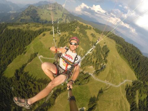 a man flying through the air on a parachute at Pension Seighof in Saalbach Hinterglemm