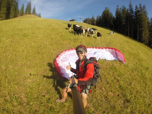 a man is sitting in a field with an umbrella at Pension Seighof in Saalbach Hinterglemm