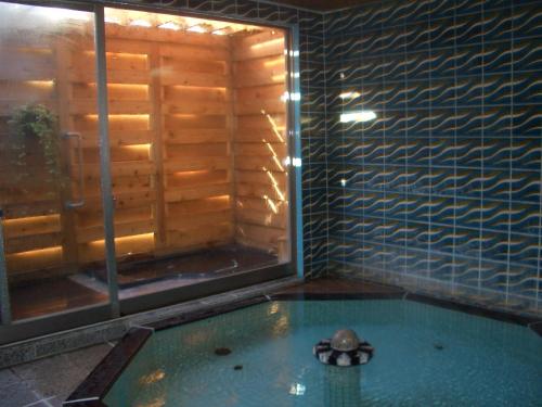 a swimming pool with a turtle in a room with a window at Tomitaya Ryokan Bekkan in Matsumoto