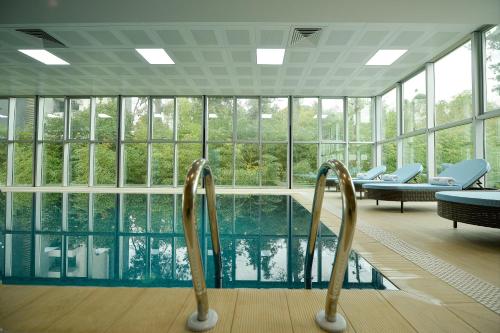 a swimming pool in a building with windows at Calligraphy Hotel and Cottages in Mtsvane Kontskhi