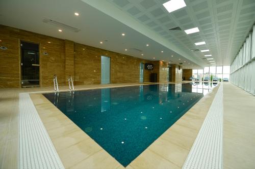 a large swimming pool in a large building at Calligraphy Hotel and Cottages in Mtsvane Kontskhi