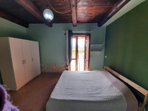 1 dormitorio con 1 cama en una habitación con paredes verdes en Appartamento di Claudia in campagna, Locazione turistica, en Spoleto