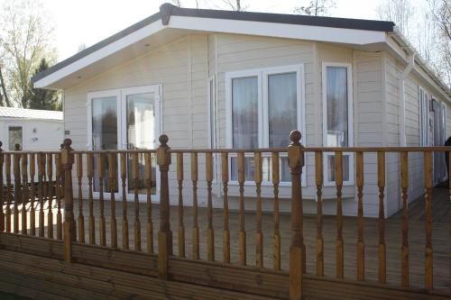 a house on a deck with a fence at St Andrew's Retreat in Tydd Saint Giles