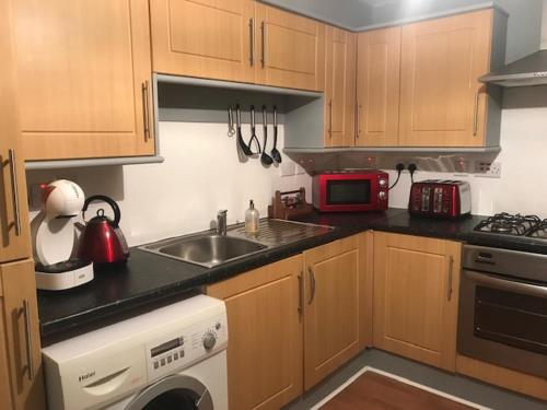 a small kitchen with a sink and a microwave at Wallace Hide Out in Glasgow