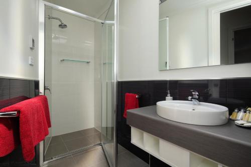 a bathroom with a sink and a glass shower at Penguin Waterfront Escape in Penguin