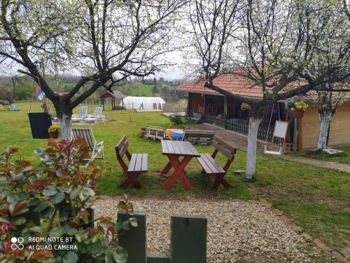 a picnic table and benches in a park with a tent at Dečiji vinogradi Belgrade, Sopot, Kosmaj in Sopot