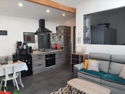 sala de estar con sofá y cocina en petite maison sympathique plein de charme, en Beychac-et-Caillau