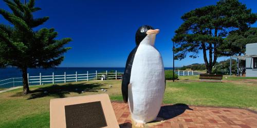 a statue of a penguin standing on top of a plaque at Penguin Waterfront Escape in Penguin