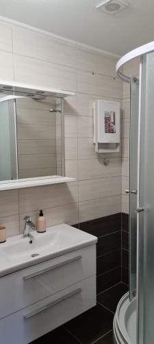 a bathroom with a sink and a mirror and a shower at Luxury apartments Oasis in Lumbarda