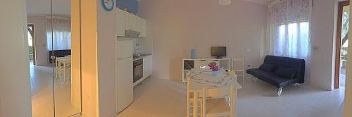 a kitchen and living room with a table and a couch at Residence Torre Delle Viole in Marina di Camerota