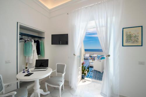 a white room with a table with a laptop on it at Terrazza Zaffiro in Positano